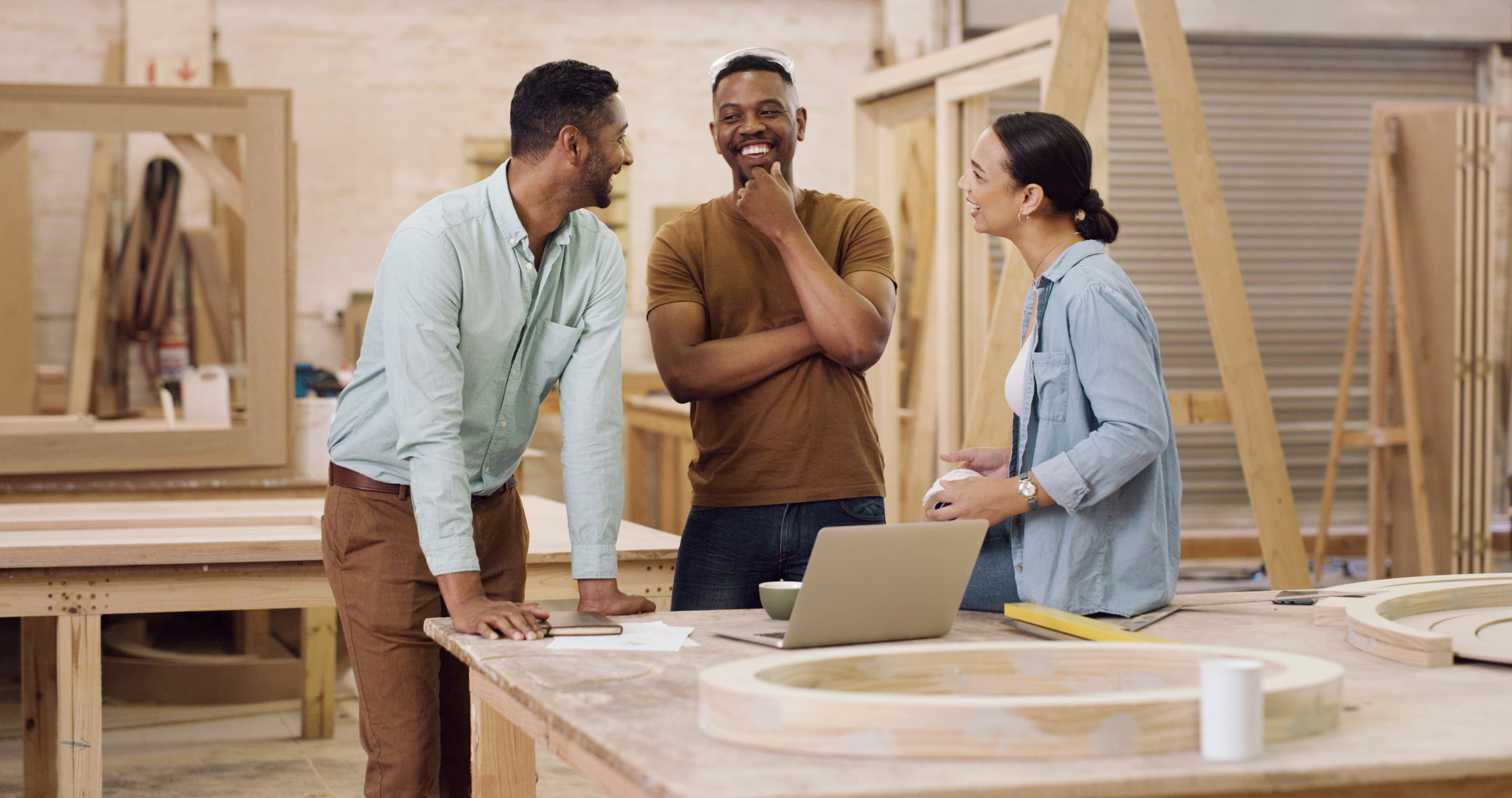 Three colleagues having an engaged discussion in a workshop