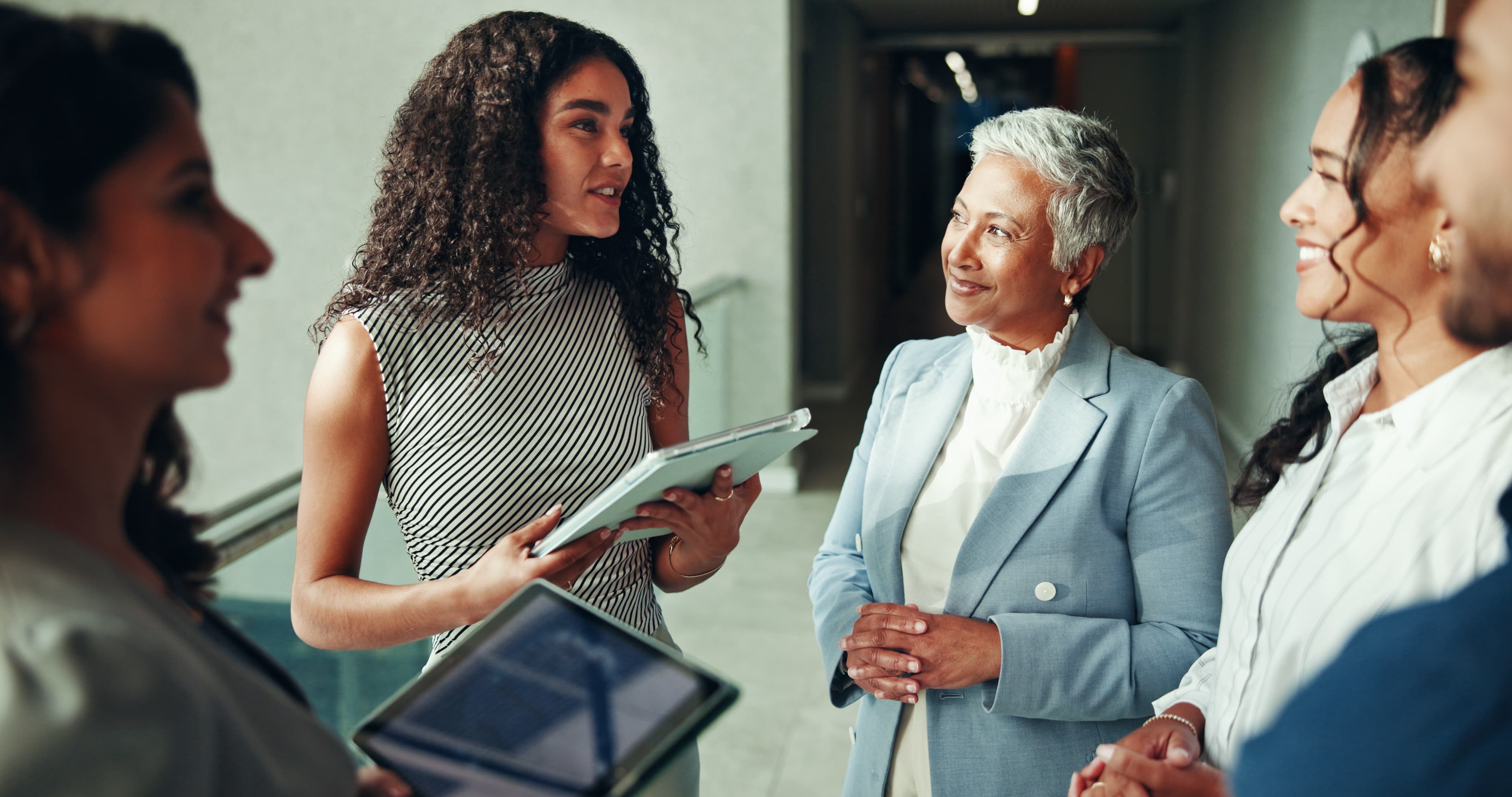 Woman presenting to a group of professional women in a lobby